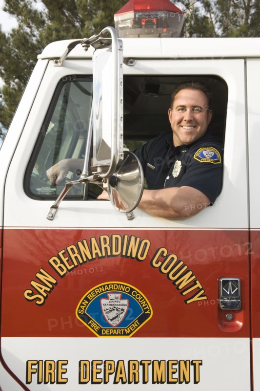 Caucasian firefighter smiling in fire truck
