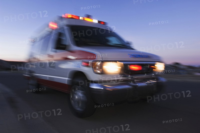 Blurred view of ambulance driving at dusk
