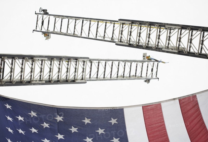 Low angle view of crane ladders and American flag