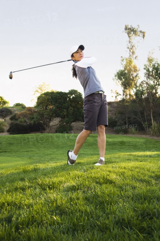 Mixed race woman playing golf on golf course