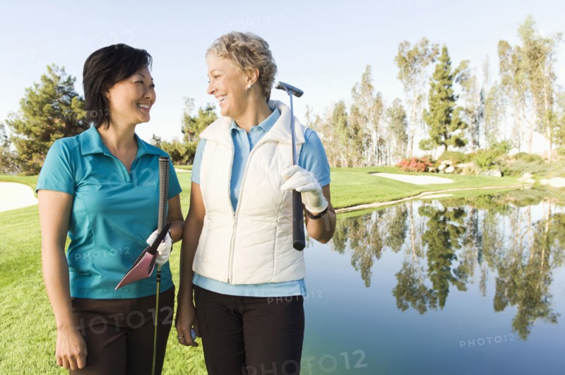 Women laughing on golf course near water hazard