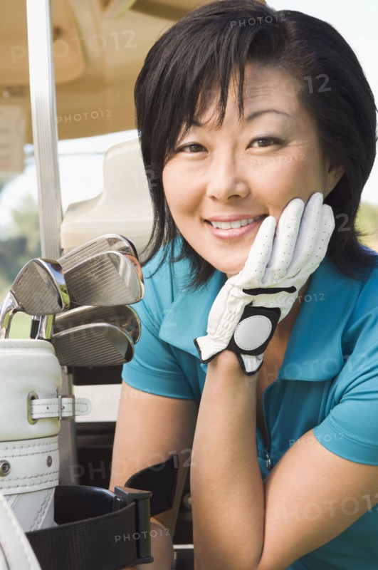 Korean woman smiling with golf clubs