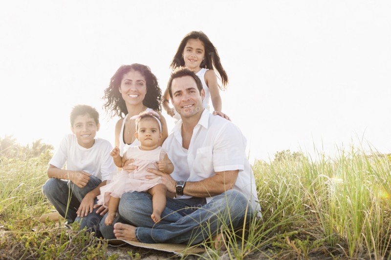 Portrait of Mixed Race family sitting in grass