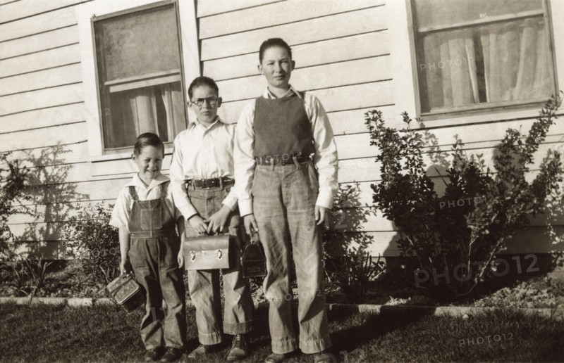 Portrait of Caucasian brothers posing near house