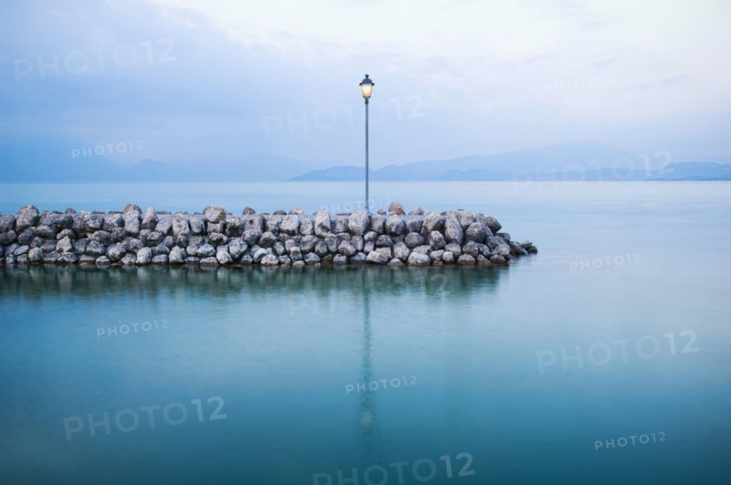 Lamp on stone breakwall in ocean