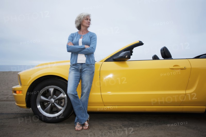 Caucasian woman leaning on convertible