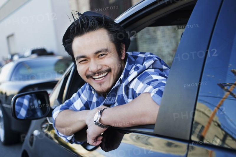 Smiling mixed race man in compact car