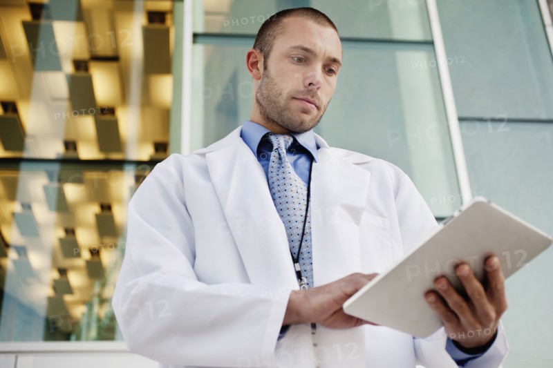 Doctor using digital tablet outdoors