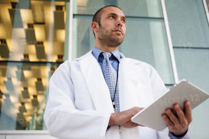 Doctor using digital tablet outdoors