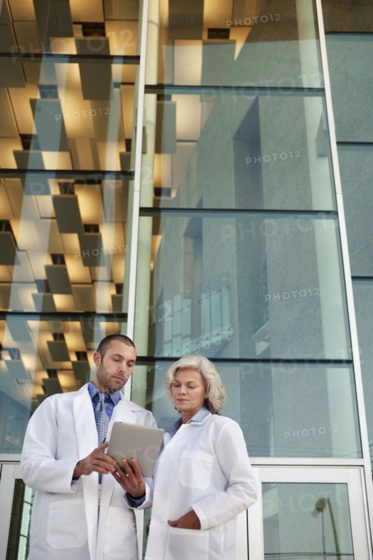 Doctor's using digital tablet outdoors