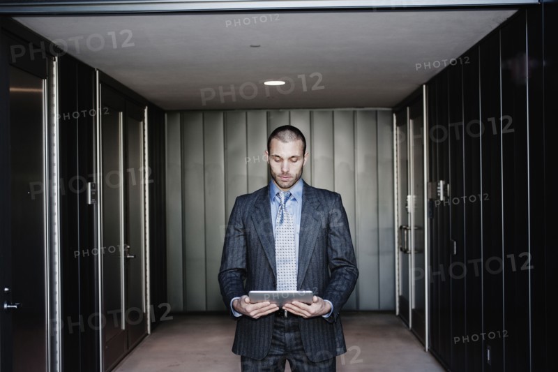 Businessman using digital tablet in corridor