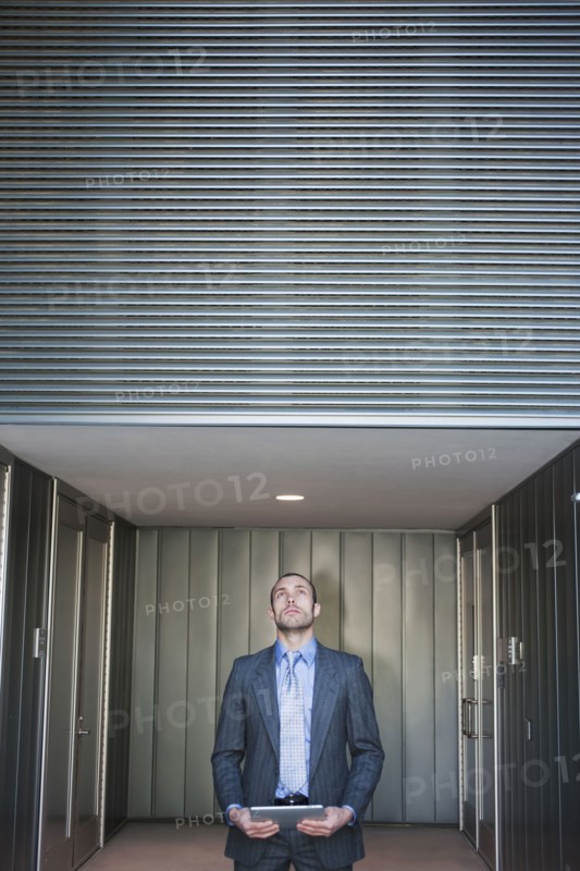 Businessman using digital tablet in corridor