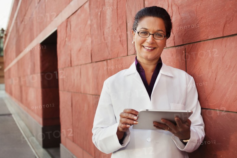 Doctor using digital tablet outdoors