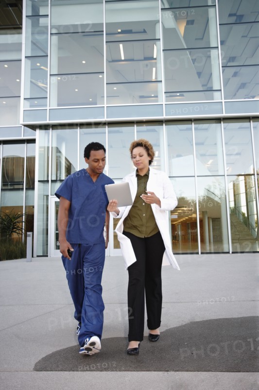 Doctor and co-worker looking at digital tablet