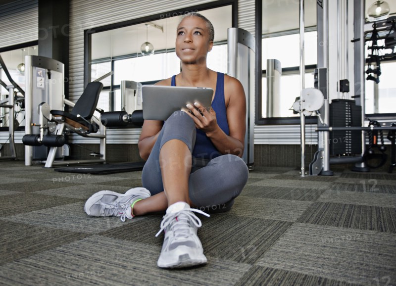 African American woman using digital tablet in health club