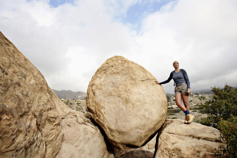 Black woman leaning against rock