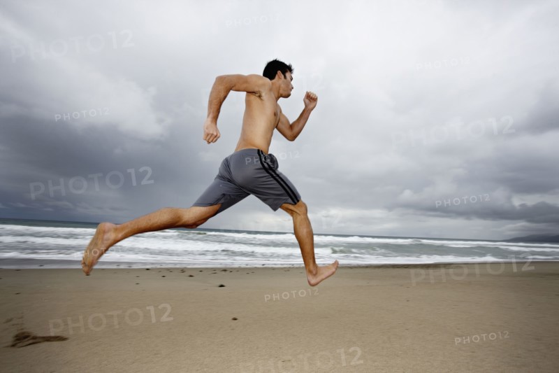 Young man running on beach