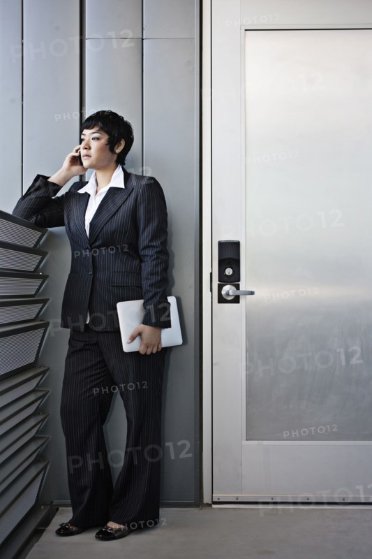 Businesswoman talking on cell phone and holding digital tablet