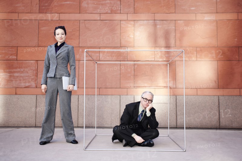 Businesswoman standing next to co-worker in box