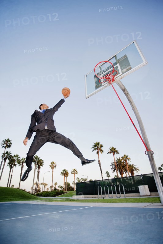 Businessman playing basketball outdoors