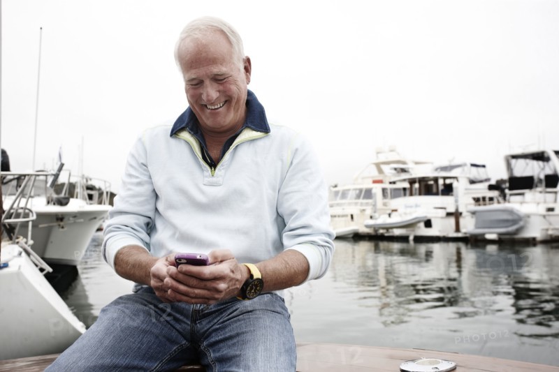 Man using cell phone in marina
