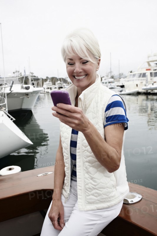 Woman using cell phone in marina