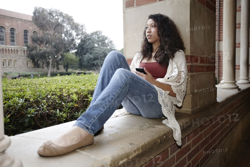 Mixed race student sitting on campus