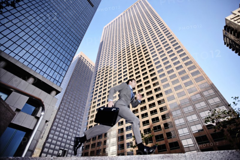 Businessman running past highrise building