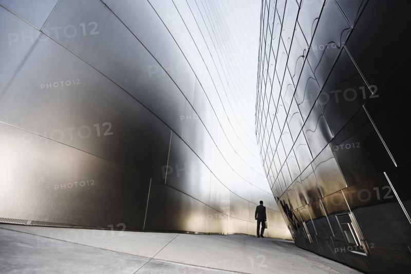 Businessman walking in urban alley