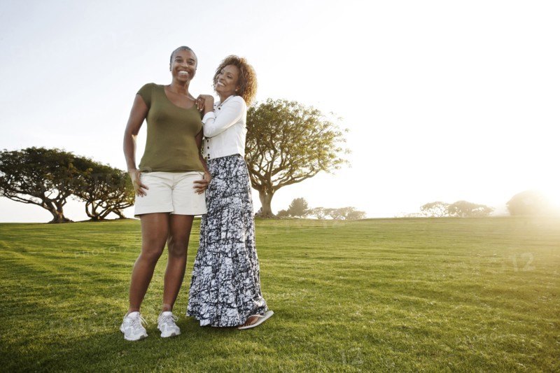 African American mother and daughter standing in park