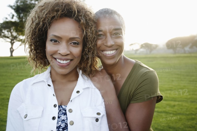 African American mother and daughter standing in park