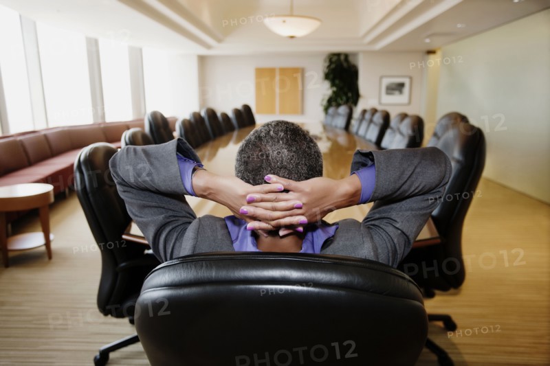 Black businesswoman sitting in empty conference room