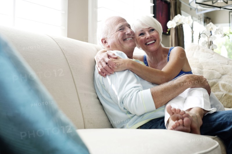 Caucasian couple hugging on sofa