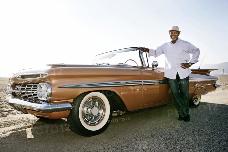 Black man leaning on convertible