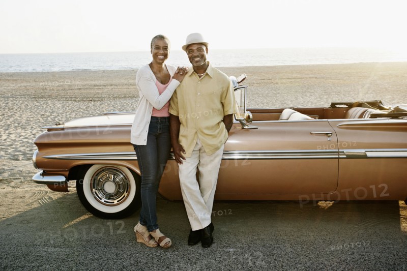 Black couple standing by convertible