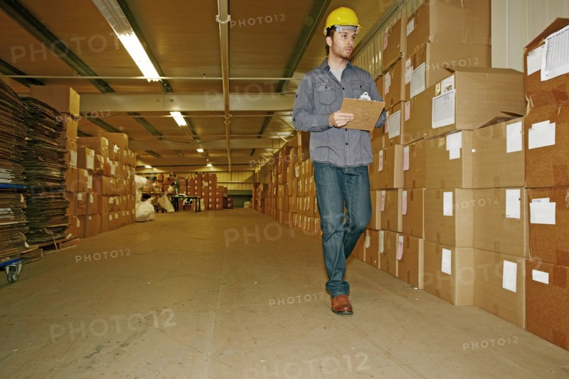 Caucasian worker checking product in warehouse