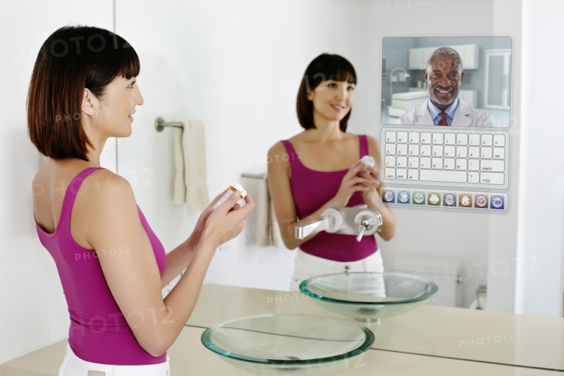 Mixed race woman using computer in mirror