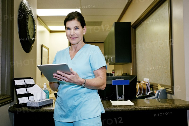 Caucasian nurse using digital tablet in office