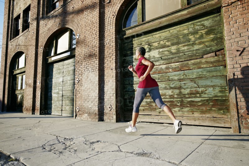 Black woman running on city street