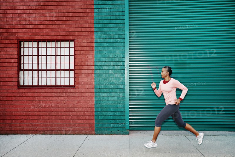 Black woman running on city street