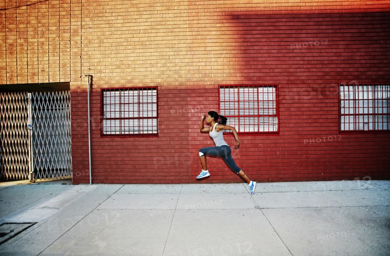 Black woman running on city street