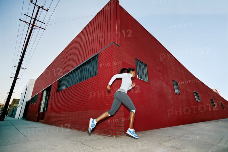 Black woman running on city street