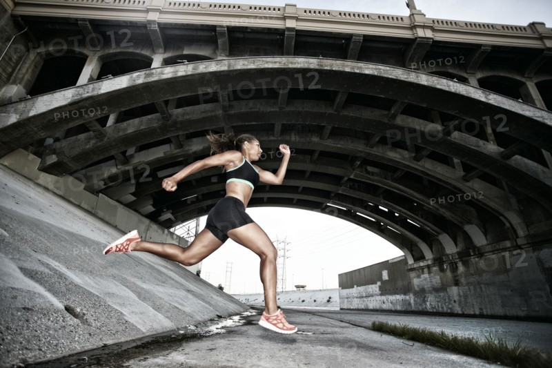 African American runner under overpass