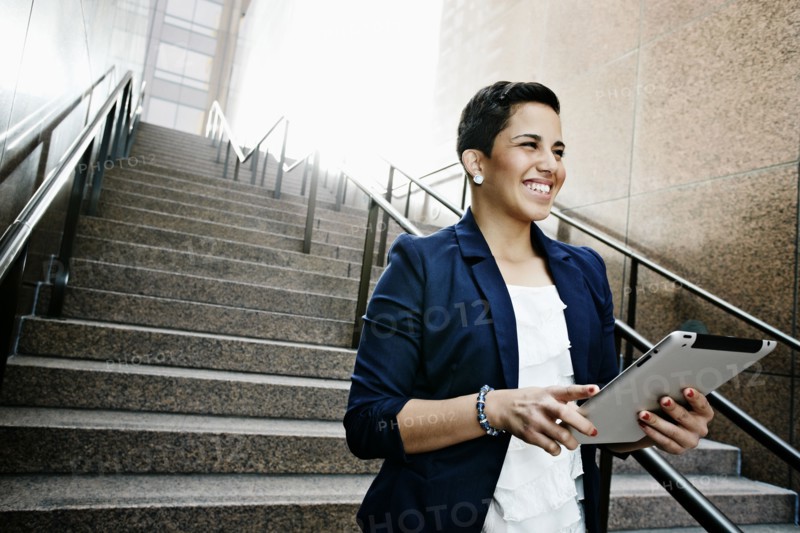 Hispanic businesswoman using tablet computer