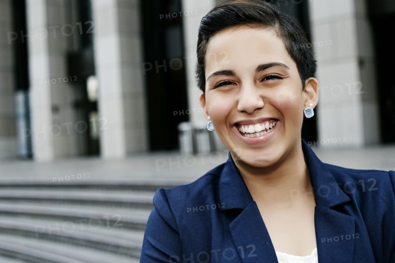 Hispanic businesswoman laughing outdoors