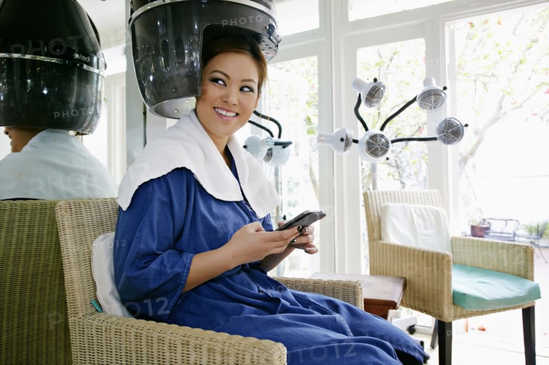 Asian woman having hair done in salon