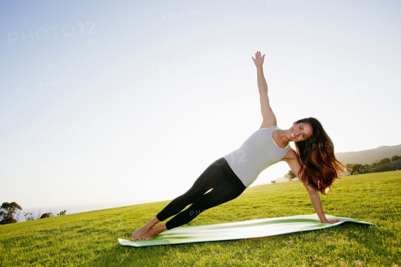 Mixed race woman practicing yoga in park