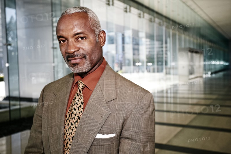 Black businessman smiling in office corridor