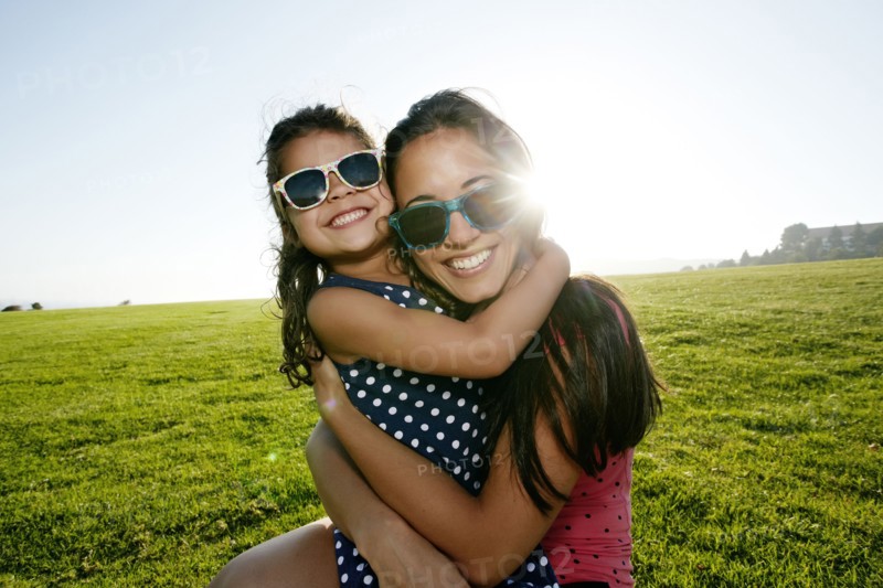 Mother and daughter smiling in field