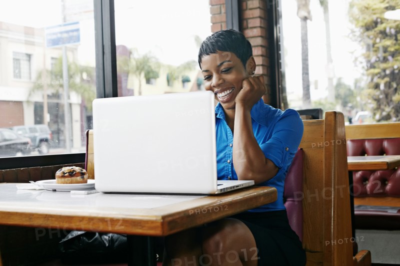 African American businesswoman using laptop in restaurant